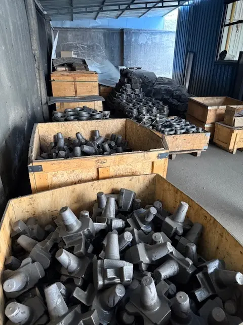 Heavy-duty iron castings and forged metal components staged in wooden crates for the production of Harlan Global aircraft tugs and industrial tractors.