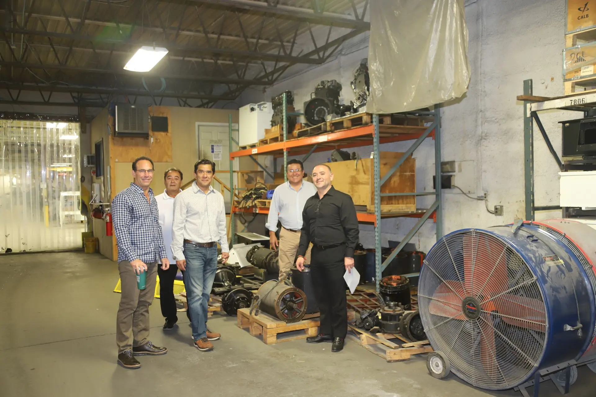 CEO Jamie Kaplan and Aero-Mexico representatives touring the headquarters warehouse, discussing the global impact of specialized Harlan tractor parts and aviation ground support equipment.